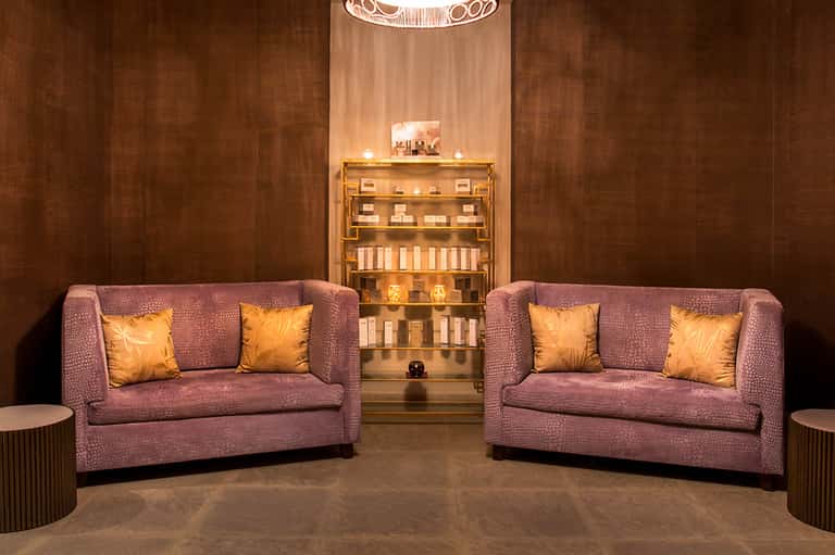 Spa retail display with illuminated shelving showcasing skincare and beauty products in warm lighting