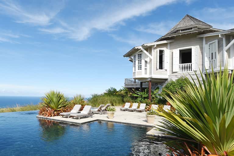 Luxury beachfront house with infinity pool, ocean view, and white modern architecture