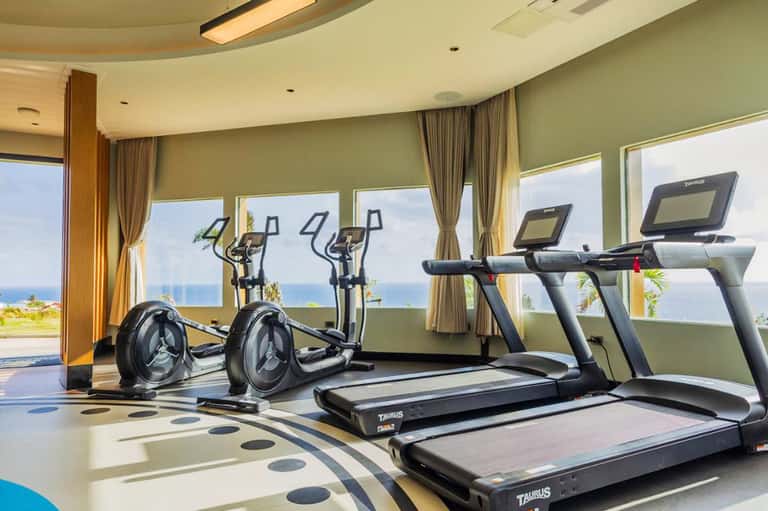 Fitness center with treadmills and exercise bikes overlooking ocean and coast