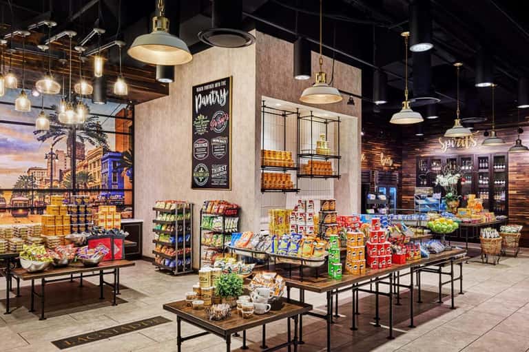 Modern market-style retail space with hanging lights, product displays, and murals