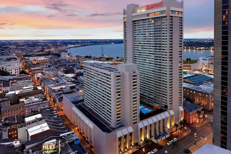 Marriott hotel tower at dusk overlooking city, waterfront, and illuminated cityscape