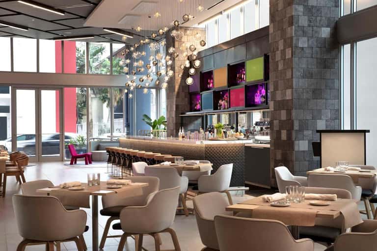 Modern hotel restaurant interior with bar, hanging lights, and contemporary decor