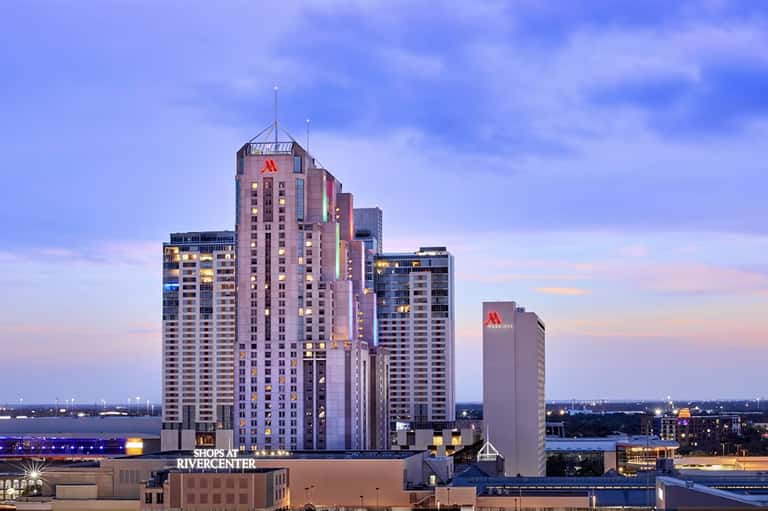 Downtown skyline at dusk with illuminated high-rise buildings and river view