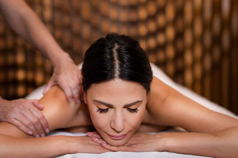 Woman receiving a relaxing back massage at a spa with warm lighting