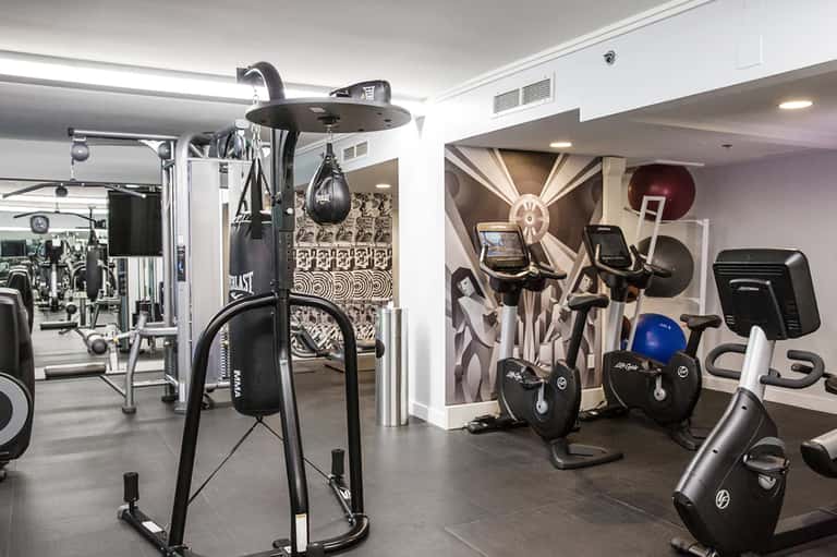 Modern fitness center with cardio equipment, dumbbells, and mirrored walls