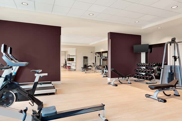 Modern fitness center with exercise bikes, weights, and gym equipment