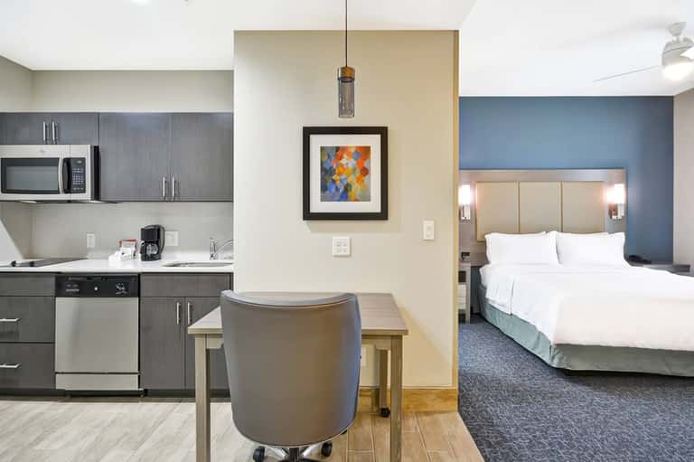 Hotel suite with kitchenette, dining area, and bedroom