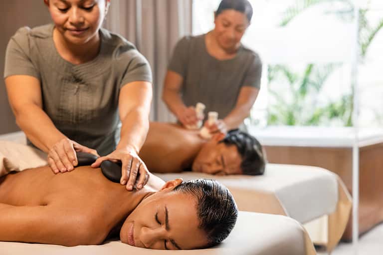 Spa therapists providing relaxing massages to clients on treatment beds