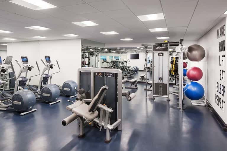 Modern fitness center with cardio equipment, weight machines, and exercise balls
