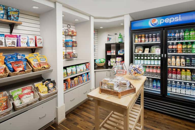 Modern convenience store interior with refrigerated beverage coolers, snacks, and Pepsi signage
