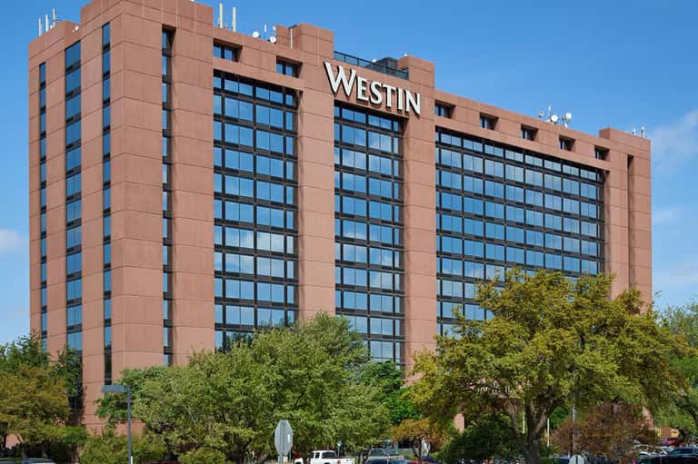 Exterior of The Westin hotel, a multi-story brick building with large windows and signage