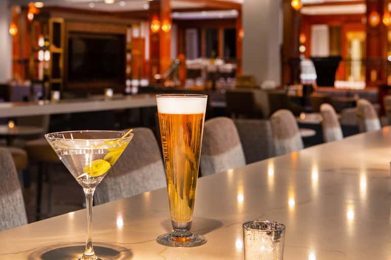 Elegant cocktails on a marble bar counter in a luxury hotel lounge with warm lighting