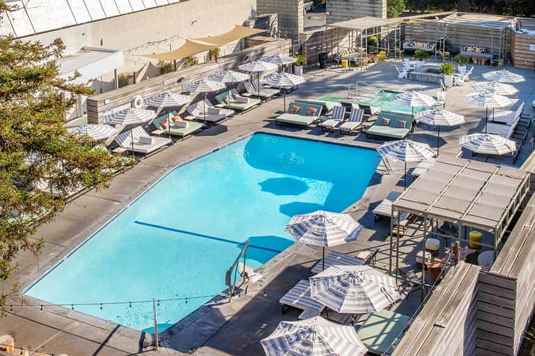Aerial view of resort pool deck with loungers, umbrellas, and multi-level facilities