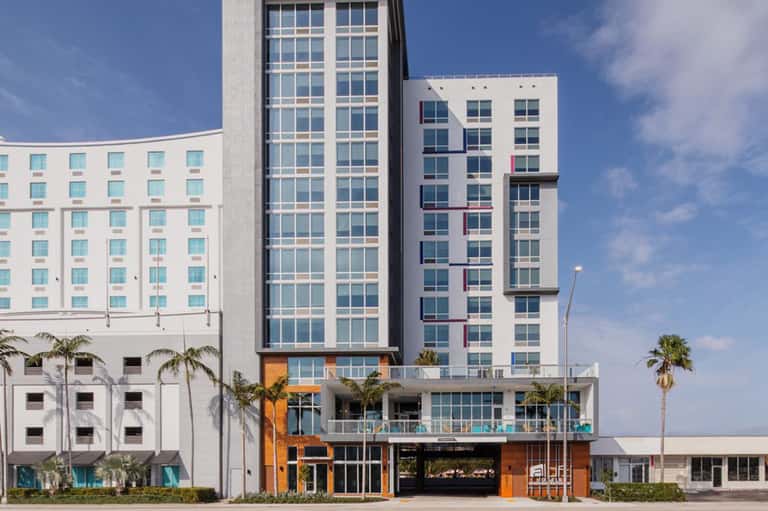 Modern beachfront hotel exterior with contemporary architecture and palm trees