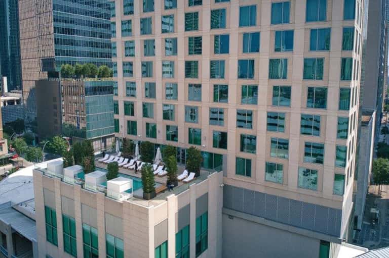 Rooftop pool area surrounded by tall residential buildings with modern architecture