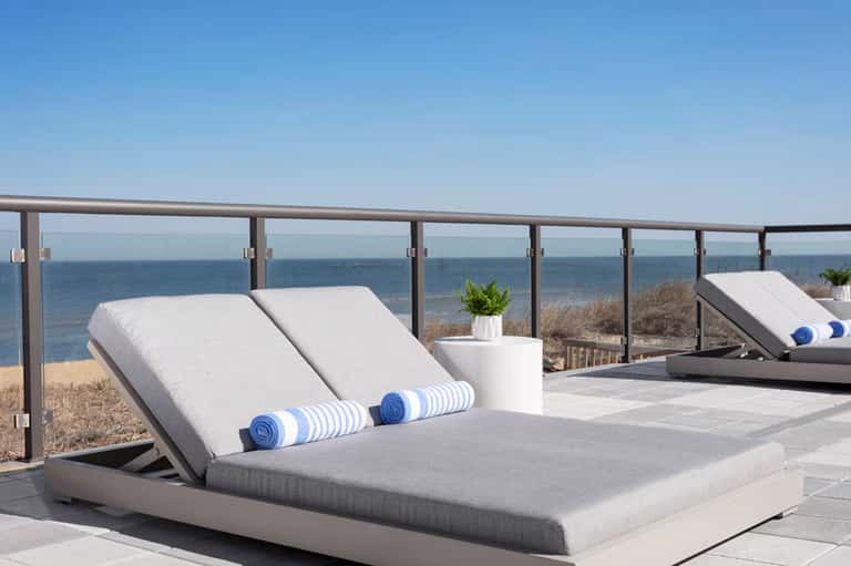 Modern lounge chairs with ocean and beach views from coastal terrace