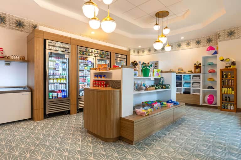 Bright retail shop interior with beverage coolers, colorful merchandise displays, and modern fixtures