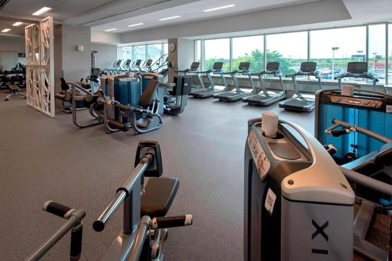 Fitness center with cardio equipment, treadmills, and large windows overlooking landscape