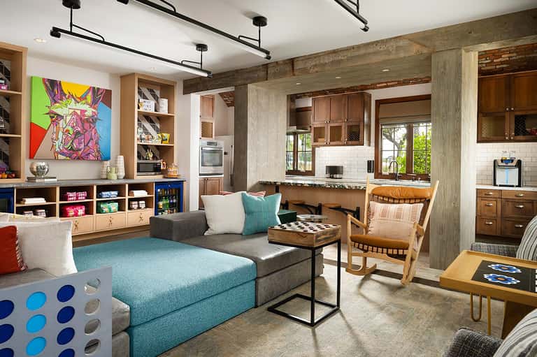 Modern playroom with turquoise sectional sofa, kitchenette, and colorful pop art