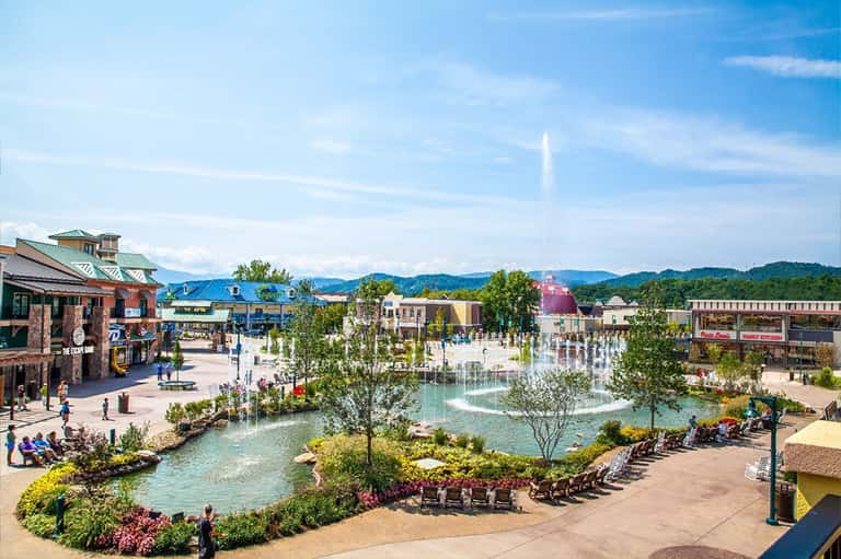 Aerial view of outdoor entertainment plaza with fountain, shops, and manicured landscaping
