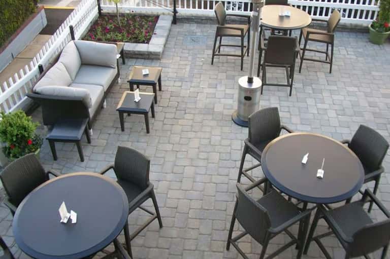 Overhead view of patio with round dining tables, bar seating, and lounge area on pavers