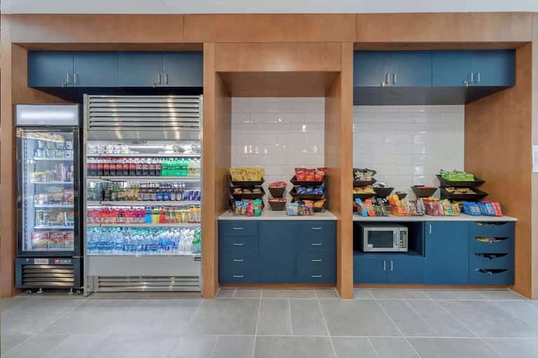 Hotel convenience store with refrigerated beverages, snacks, and microwave