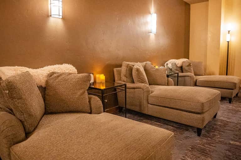 Comfortable relaxation lounge with beige upholstered seating and soft accent lighting