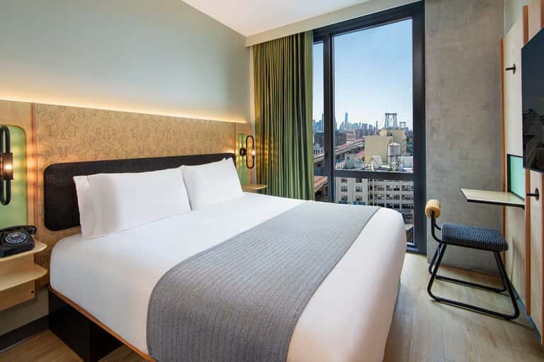 Luxury hotel bedroom with cityscape view, modern furnishings, and contemporary design