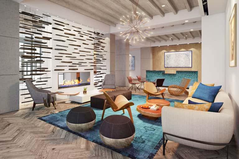 Contemporary hotel lobby with fireplace, modern furniture, turquoise accents, and artistic decor