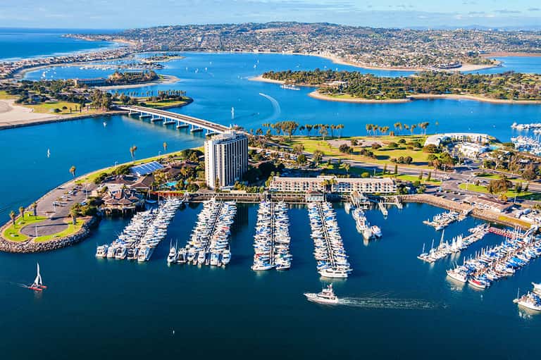 Aerial view of marina with organized boat docks and surrounding coastal landscape with bridges