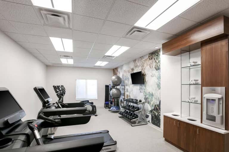 Modern fitness center with treadmills, dumbbells, and motivational wall artwork