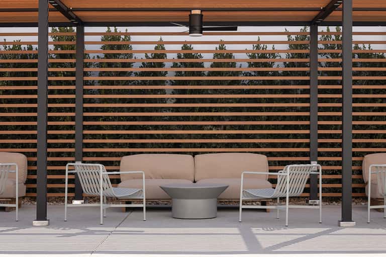 Modern outdoor patio with beige sofa, white chairs, and horizontal wood slat privacy screen