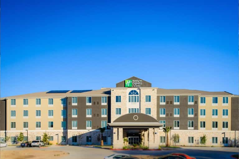 Holiday Inn Express hotel exterior with tan and brown facade under clear blue sky
