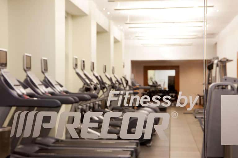 Fitness center interior with rows of treadmills and exercise equipment