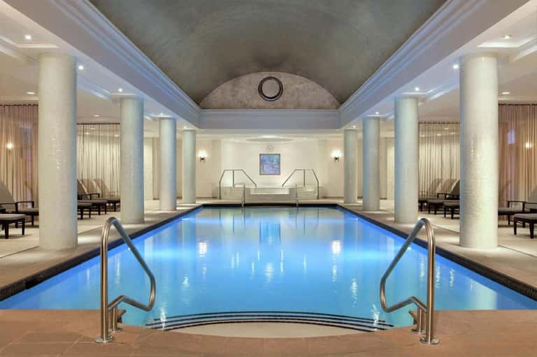 Indoor lap pool with marble columns and elegant classical design