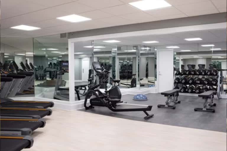 Modern fitness center with treadmills, stationary bikes, and mirrored walls