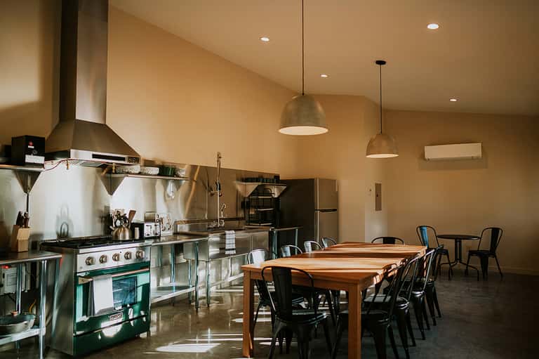 Modern open kitchen and dining area with stainless steel appliances and pendant lighting