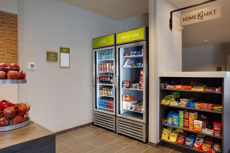 Hotel convenience market with refrigerated beverage cases and snack shelves
