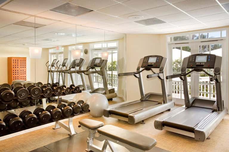 Fitness center with treadmills, dumbbells, and exercise equipment near bright windows