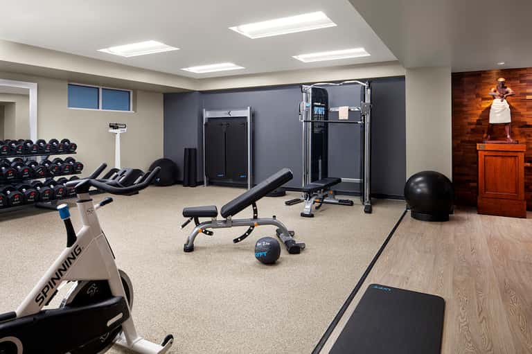 Fitness center with dumbbells, exercise equipment, stationary bikes, and weight machines