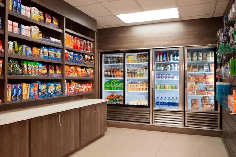 Convenience store interior with shelves of snacks and refrigerated beverages