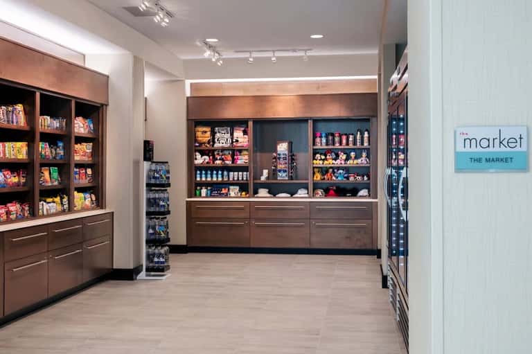 Modern gift shop interior with brown wooden display cabinets and shelving units stocked with merchandise