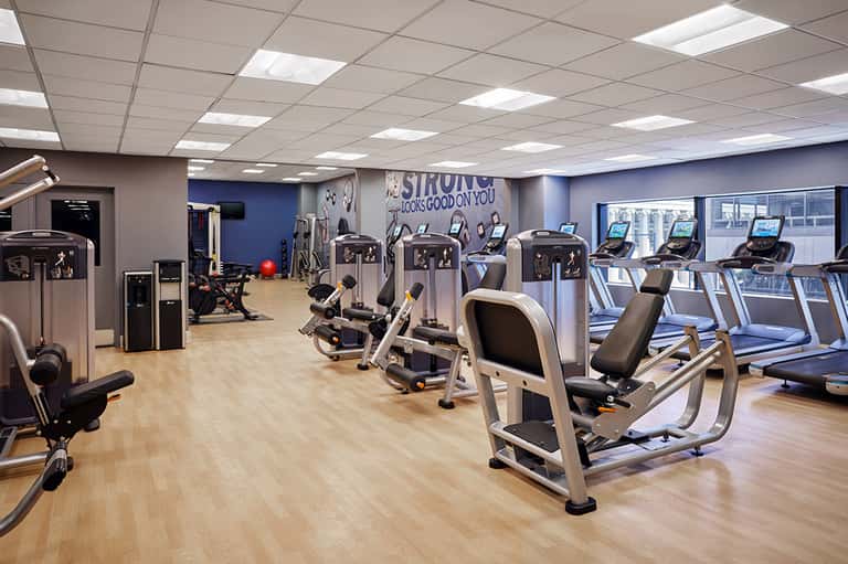 Modern fitness center with cardio machines, strength equipment, and motivational wall signage