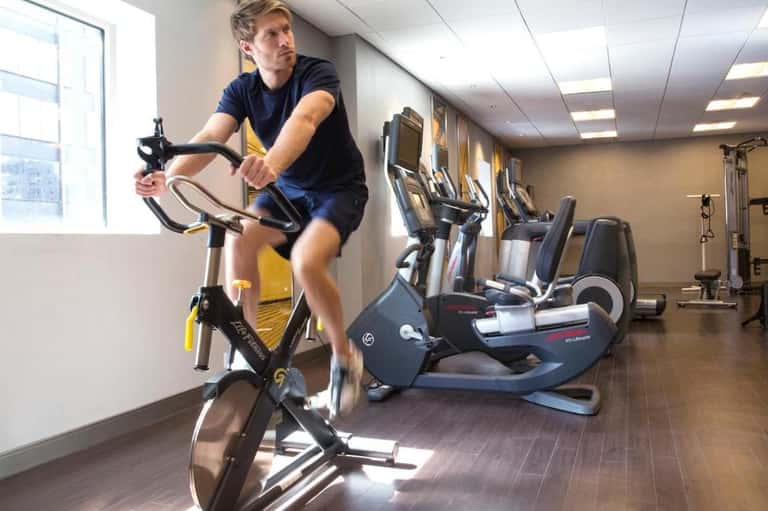 Resort fitness center with stationary bikes, exercise equipment, and bright natural light from windows