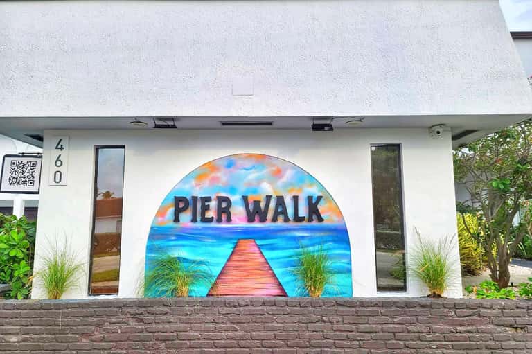 White storefront with colorful pier mural artwork and address number 460