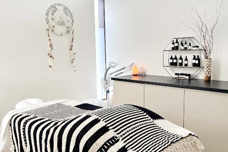 Minimalist bedroom with striped black and white bedding, dream catcher wall art, and modern furnishings