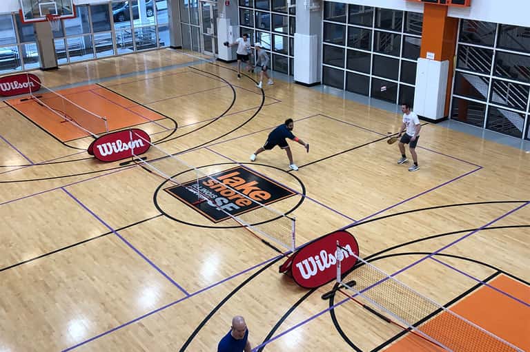 Indoor basketball court with wooden floor and Wilson equipment during active game play