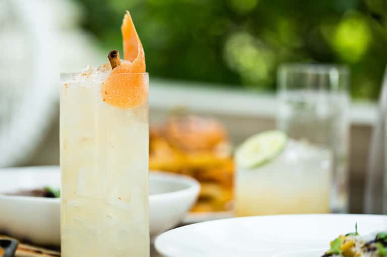 Refreshing cocktail with grapefruit garnish on outdoor dining table