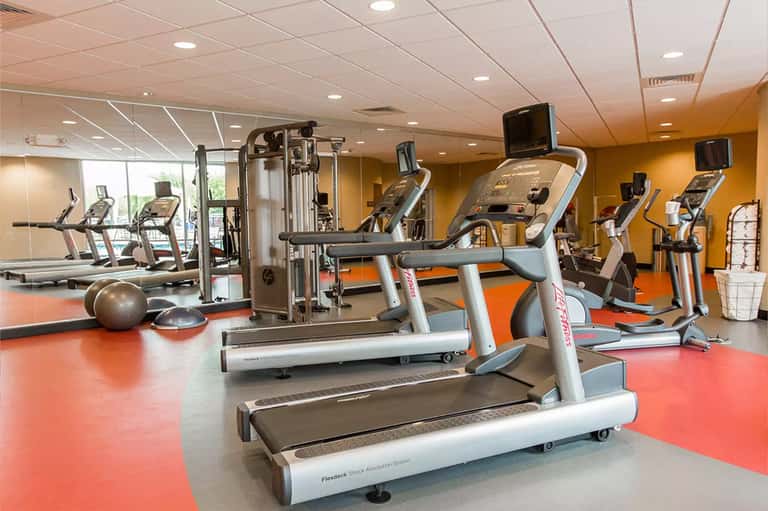 Modern fitness center with multiple treadmills, exercise bikes, and gym equipment