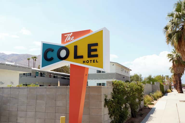 The Cole Hotel retro mid-century sign with mountains and palm trees in background